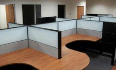 an empty office cubicle with wooden desks