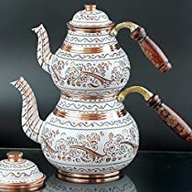 a white and gold tea pot with a pipe on it, next to another one