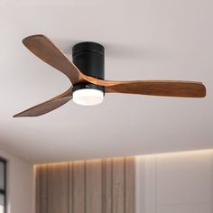 a black ceiling fan with wooden blades in a room