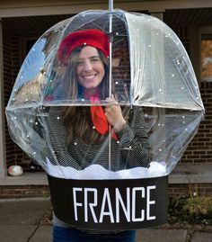 a woman holding an umbrella with the word france written on it in front of her face