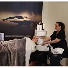 a woman is getting her foot massage at the doctor's office in front of a poster