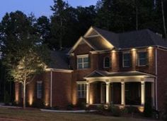 a large brick house with lights on it's windows