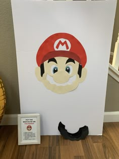 an image of a mario paper cut out on the floor next to a sign that says mario