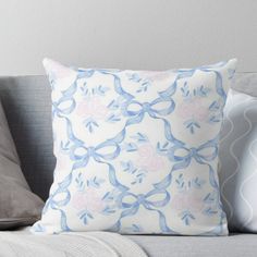 a blue and white pillow sitting on top of a couch