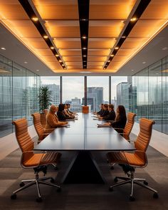 a group of people sitting at a conference table in an office setting with large windows