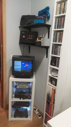 there is a small tv on top of a shelf in the room with video games