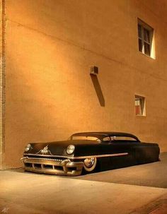 an old black car parked in front of a building