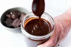 a person is pouring chocolate into a jar