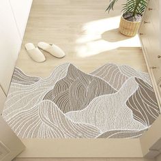 a bathroom with a rug on the floor that looks like mountains and rocks is next to a potted plant