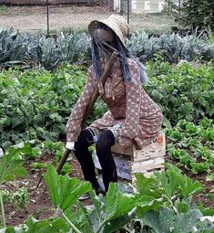 a woman sitting on top of a wooden box in a garden filled with green plants