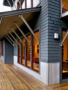 a house that has some windows on the outside and wood floors in front of it