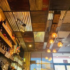 a bar with lots of lights hanging from the ceiling and shelves filled with liquor bottles