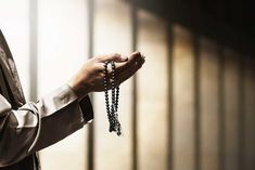 a person holding rosary beads in their hand