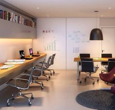 an office with desks and chairs in the middle, along with bookshelves