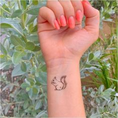 a small squirrel tattoo on the wrist