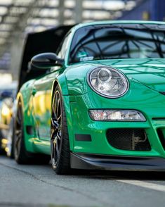 a green sports car is parked on the street