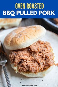 bbq pulled pork sandwich on a white plate with fork and blue text overlay that says oven roasted bbq pulled pork