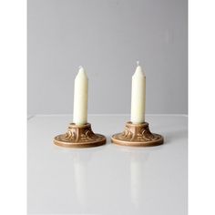 two white candles sitting on top of each other