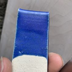 a blue and white object being held in someone's hand