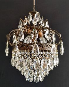 a chandelier hanging from the ceiling with lots of crystal drops on it's sides