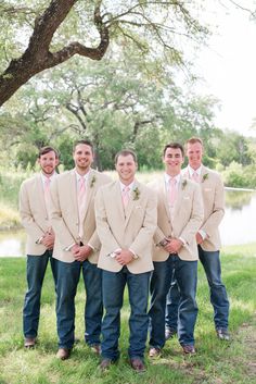 a group of men standing next to each other in front of a tree