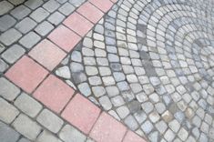 a white frisbee sitting on top of a brick road next to a sidewalk