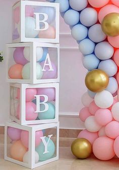 baby blocks are stacked with balloons in the shape of letters