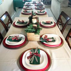 the table is set for christmas dinner with red and green plates