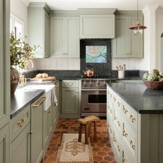 two pictures of a kitchen with green cabinets