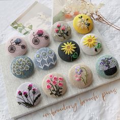 a bunch of buttons that are sitting on a cloth covered surface with flowers in them