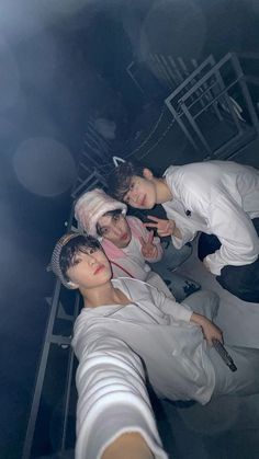 three young men in white outfits are posing for the camera