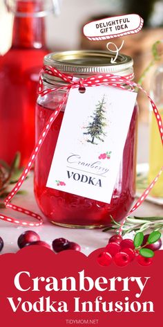 cranberry vodka in a mason jar with red berries around it and the label