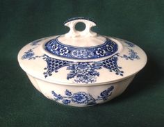 a blue and white covered dish on a green surface