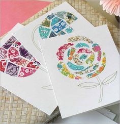 three cards with different designs on them sitting next to each other and one has a flower in the middle