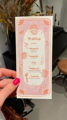 a person holding up a menu card in their hand with the word menu on it