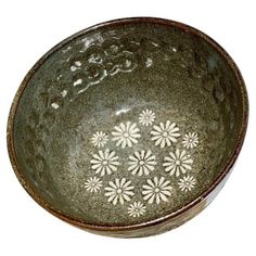 a green bowl with white flowers on it