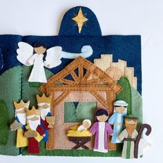 a felt nativity scene is displayed on a white surface