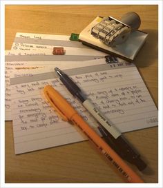 two pens and some writing paper on a table