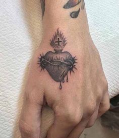 a hand with a heart and crown tattoo on it