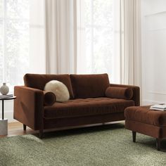 a living room scene with focus on the couch and chair, which is in front of a window