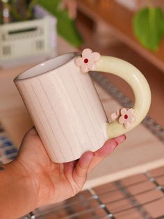 a hand holding a coffee cup with flowers on it