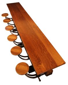 a long wooden table with six stools on it