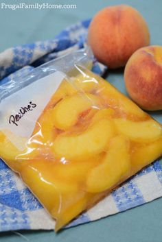 two peaches sitting on top of a blue and white towel next to some fruit