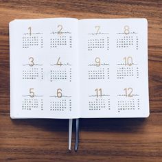 an open notebook with a calendar on the page and pen in it, sitting on top of a wooden table