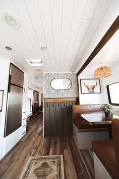 the interior of a travel trailer with wood flooring