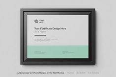 a certificate is hanging on the wall next to a black framed object with a green border