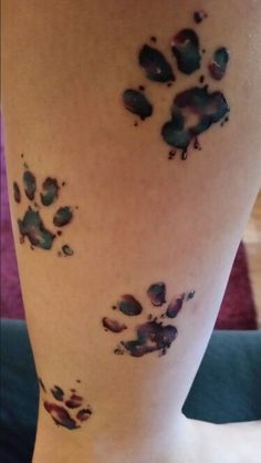 an animal paw print on the leg of a woman's legs with watercolors