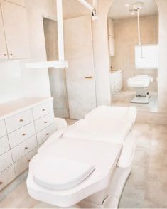 an empty bathroom with white furniture in it