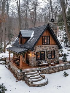 a small stone house in the snow with stairs leading up to it