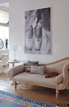 a living room filled with furniture and a painting on the wall